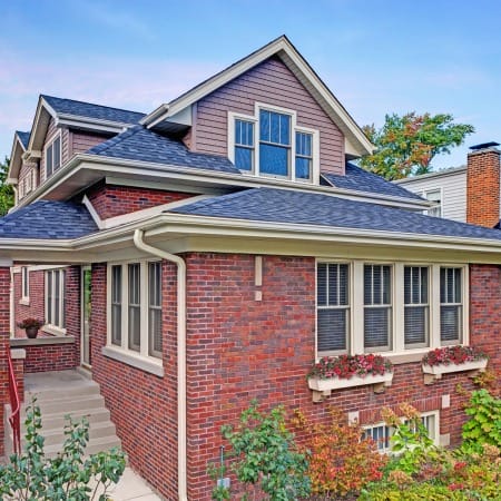 Traditional Red Brick Bungalow with Sloping Second Story and Dormers