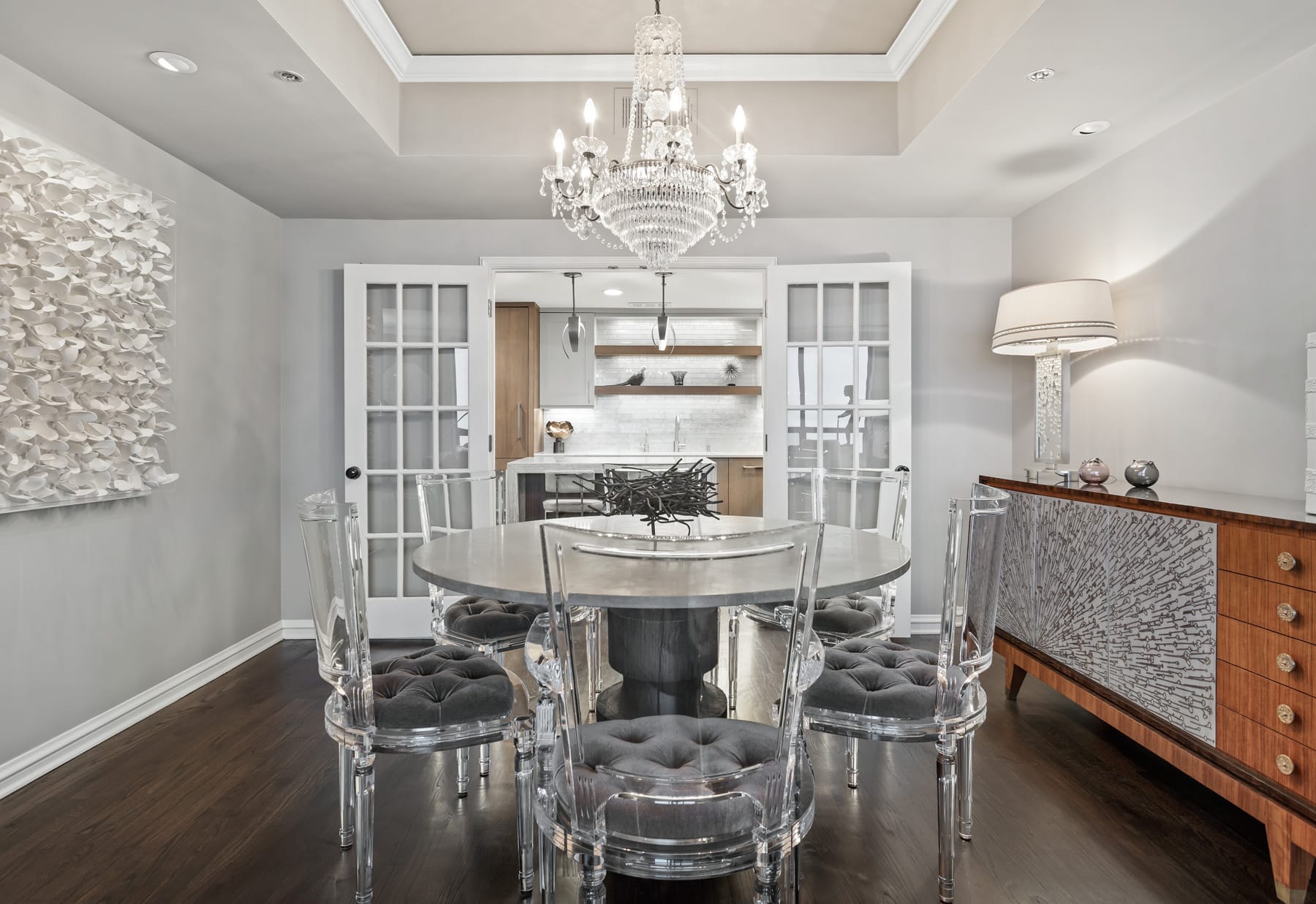 Image of a condo dining room with french doors opened to the kitchen